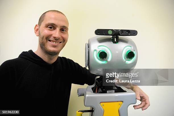 Assistant researcher of the Scuola Superiore Sant'Anna di Pisa Raffaele Esposito poses for a photo with a robot of the project Robot-Era at nursing...