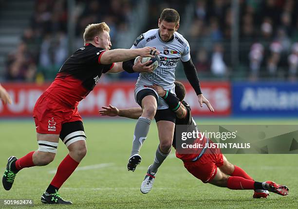 Oyonnax's full back from France Florian Denos is tackled by Saracens' flanker from England Jackson Wray and Saracens' scrum-half from South Africa...