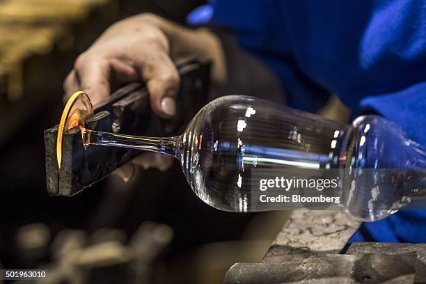 Glass worker shapes the footplate of a stemmed wine glass at the Novosad & Son Glassworks in Harrachov, Czech Republic, on Friday, Dec. 18, 2015....