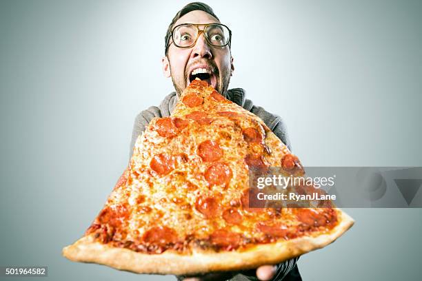man eating oversized pizza slice - binge eating stock pictures, royalty-free photos & images