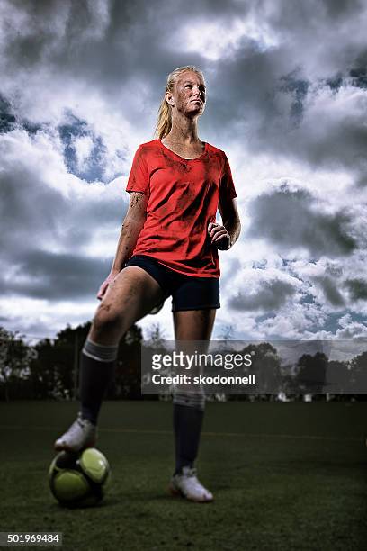 muddy teenage girl with soccer ball - standing in the rain girl stockfoto's en -beelden