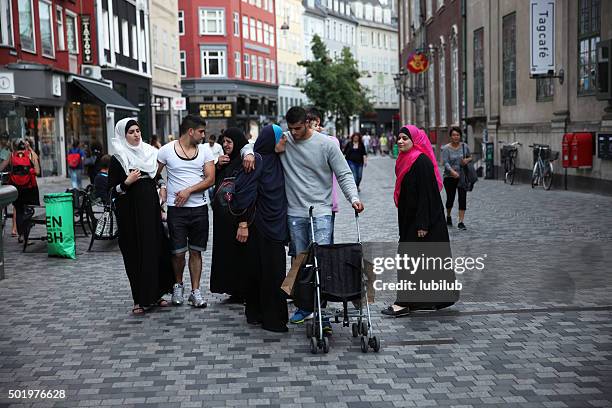moroccan family walking in copenhagen, denmark. - immigrants stock pictures, royalty-free photos & images