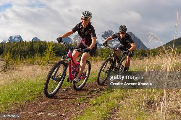 mountain bikers descend trail with speed - mountain biking fotografías e imágenes de stock