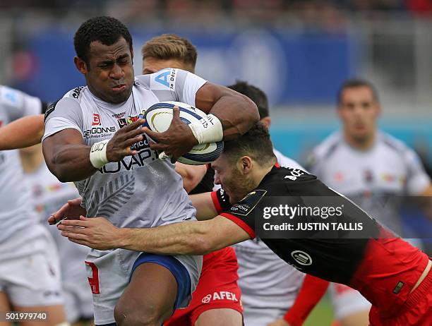 Oyonnax's centre from Fiji Uwanakaro Tawalo is tackled by Saracens' centre from Scotland Duncan Taylor during the European Rugby Champions Cup rugby...