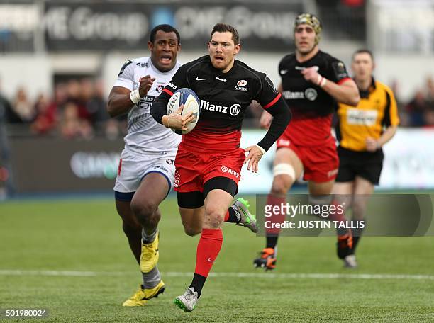 Saracens' full back from England Alex Goode runs in his try chased by Oyonnax's centre from Fiji Uwanakaro Tawalo during the European Rugby Champions...