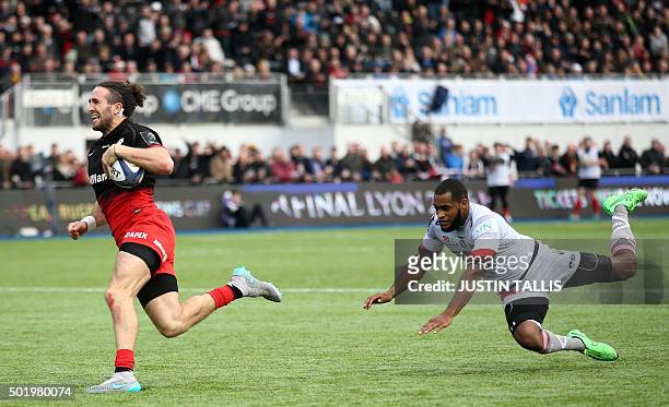 Saracens' wing from England Mike Ellery runs in his first try chased by Oyonnax's wing from Tonga Fetu'u Vainikolo during the European Rugby...