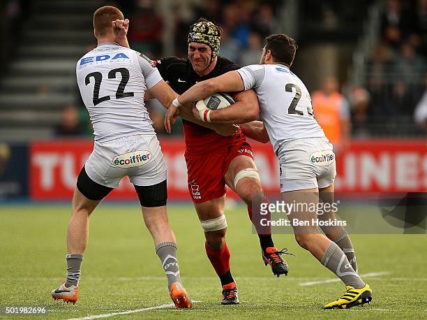 Kelly Brown of Saracens is tackled by Rory Clegg and Vincent Martin of Oyonnax during the European Rugby Champions Cup match between Saracens and...