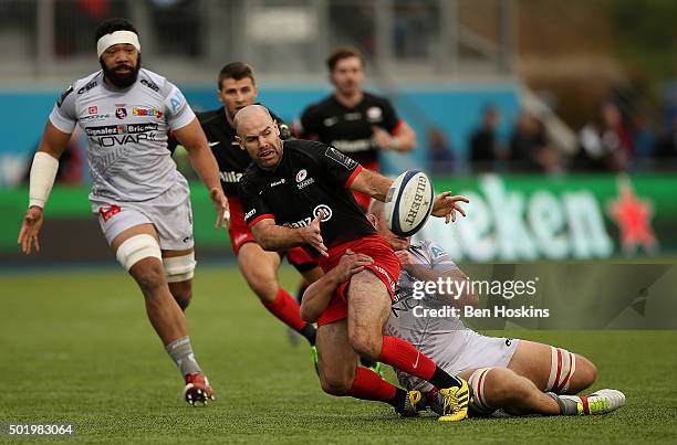 Charlie Hodgson of Saracens offloads under pressure from Geoffrey Fabbri of Oyonnax during the European Rugby Champions Cup match between Saracens...