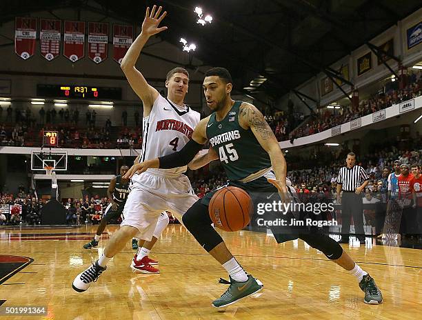 Denzel Valentine of the Michigan State Spartans drives by David Walker of the Northeastern Huskies in the first half on December 19, 2015 at the...