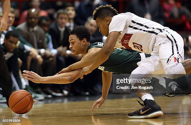 Bryn Forbes of the Michigan State Spartans beats Devon Begley of the Northeastern Huskies to the ball in the first half on December 19, 2015 at the...