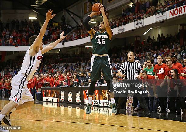 Denzel Valentine of the Michigan State Spartans shoots over Caleb Donnelly of the Northeastern Huskies in the first half on December 19, 2015 at the...