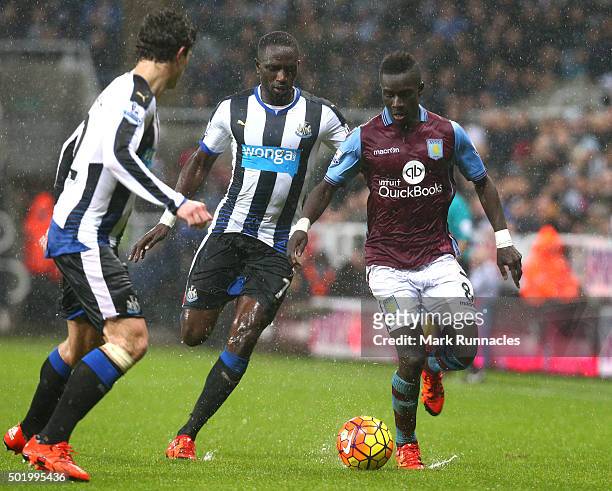 Idrissa Gueye of Aston Villa takes on Moussa Sissoko and Daryl JanMaat of Newcastle during the Barclays Premier League match between Newcastle United...