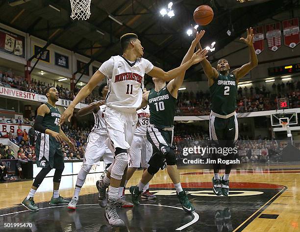 Javon Bess of the Michigan State Spartans grabs a loose ball as Jeremy Miller of the Northeastern Huskies defends in the first half on December 19,...
