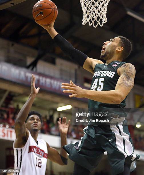 Denzel Valentine of the Michigan State Spartans shoots over the defense of Quincy Ford of the Northeastern Huskies in the second half on December 19,...