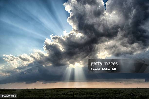 large cloud and god beams over farmland - 覚悟 ストックフォトと画像