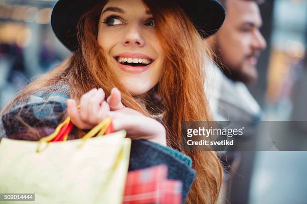 christmas shopping - couple shopping in shopping mall stockfoto's en -beelden