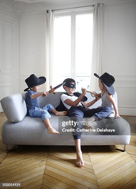 3 disguised brothers playing on a sofa - sword stock pictures, royalty-free photos & images