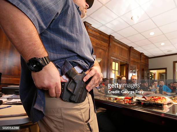 Damon Thueson shows a holster at a gun concealed carry permit class put on by "USA Firearms Training" on December 19, 2015 in Provo, Utah. Demand for...