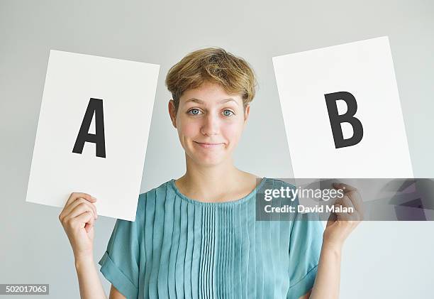 woman holding two boards marked a & b - pretty letter b stock pictures, royalty-free photos & images