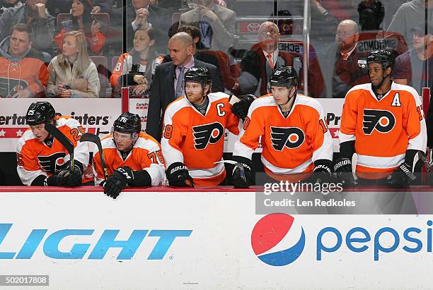 Ryan White, Chris VandeVelde, Assistant Coach Ian Laperriere, Claude Giroux, Brayden Schenn and Wayne Simmonds of the Philadelphia Flyers watch the...