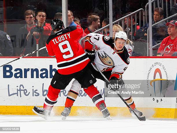 Jiri Tlusty of the New Jersey Devils and Hampus Lindholm of the Anaheim Ducks battle for position during the game at the Prudential Center on...