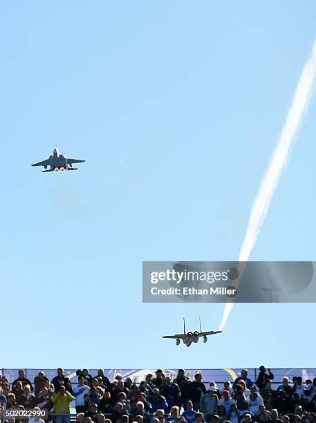 Pair of F-15C fighter jets from Nellis Air Force Base perform a flyover before the Brigham Young Cougars and Utah Utes play in the Royal Purple Las...