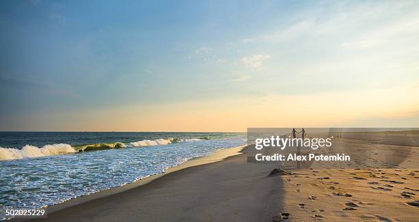 two girls walks at the jones beach at the sunset - nassau county long island stock pictures, royalty-free photos & images
