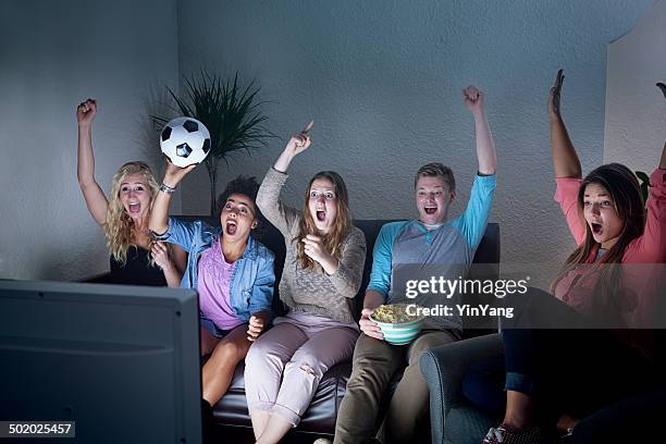 youth group watching soccer game on tv together - family watching television stock pictures, royalty-free photos & images