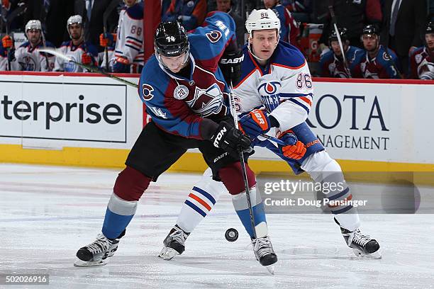 Blake Comeau of the Colorado Avalanche tries to control the puck against Nikita Nikitin of the Edmonton Oilers at Pepsi Center on December 19, 2015...
