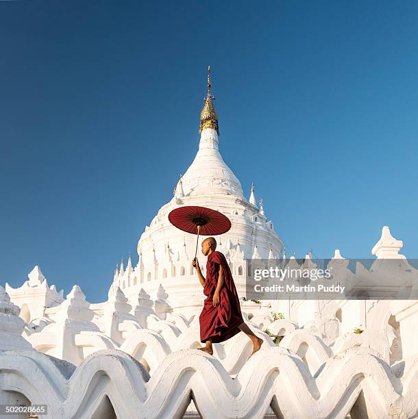 buddhist monk walking across arches of temple - monks stock pictures, royalty-free photos & images