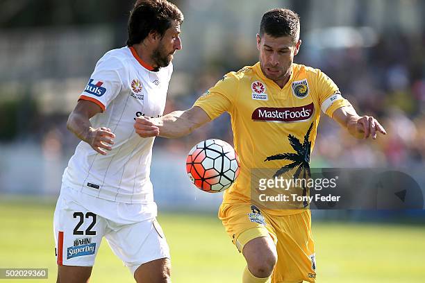 Thomas Broich of the Roar contests the ball with Nick Montgomery of the Mariners during the round 11 A-League match between the Central Coast...