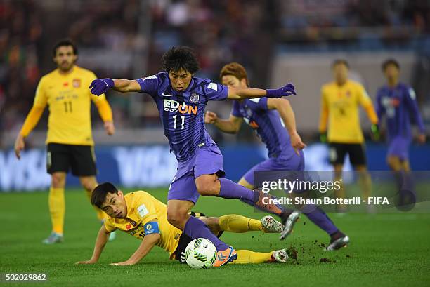 Hisato Sato of Sanfrecce Hiroshima is tackled by Zheng Zhi of Guangzhou Evergrande FC during the FIFA Club World Cup 3rd Place Match between...