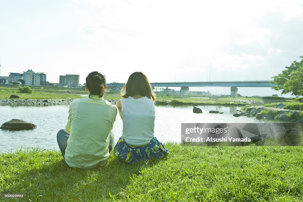 Rear view of young couple beside river