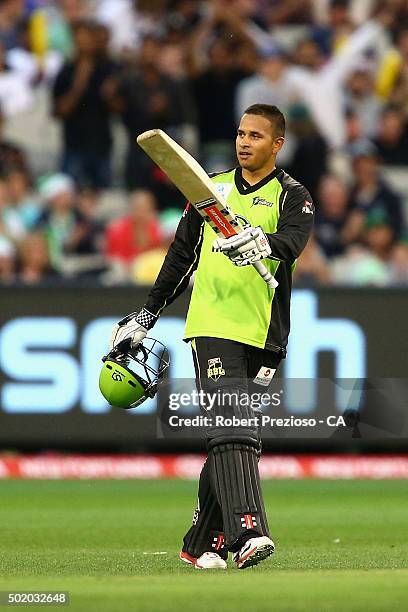 Usman Khawaja of the thunder celebrates scoring his century during the Big Bash League match between Melbourne Stars and Sydney Thunder at Melbourne...