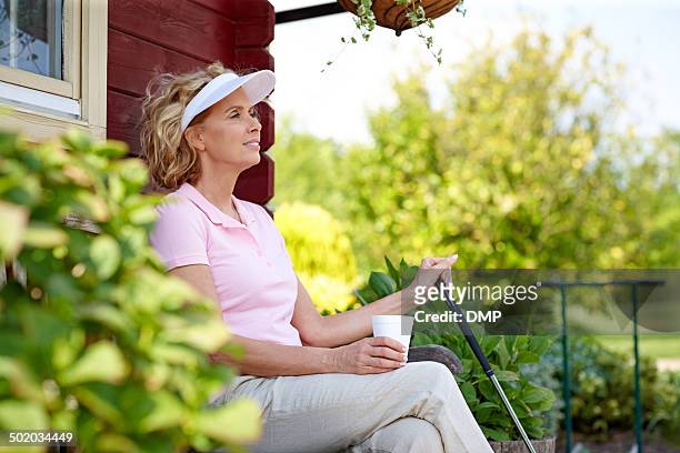 female golfer resting after a game - country club woman stock pictures, royalty-free photos & images