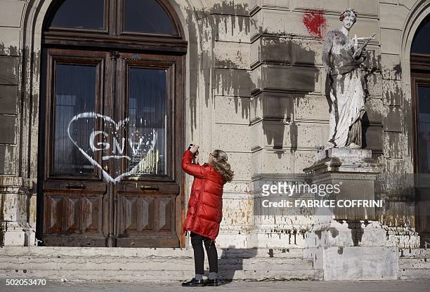 Woman snaps a picture of the "Grand Theatre de Geneve" opera house on December 20, 2015 in Geneva, after it was vandalised during a demonstration the...