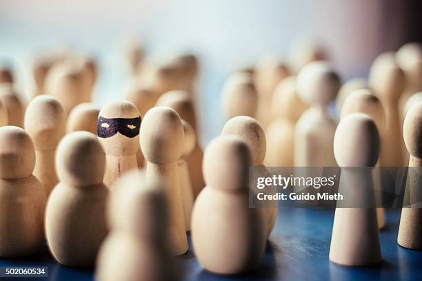 pawn with a mask in a group of faceless pawns. - chess pieces stock-fotos und bilder