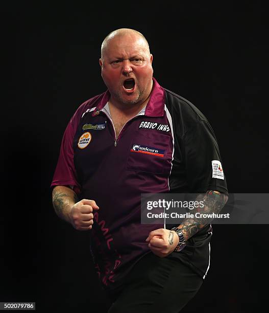 Andy Hamilton of England celebrates winning a set during his first round match against Joe Murnan of England during the 2016 William Hill PDC World...