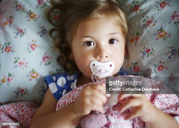 a 2 years old girl with her dummy in her bed - 2 3 years stock-fotos und bilder