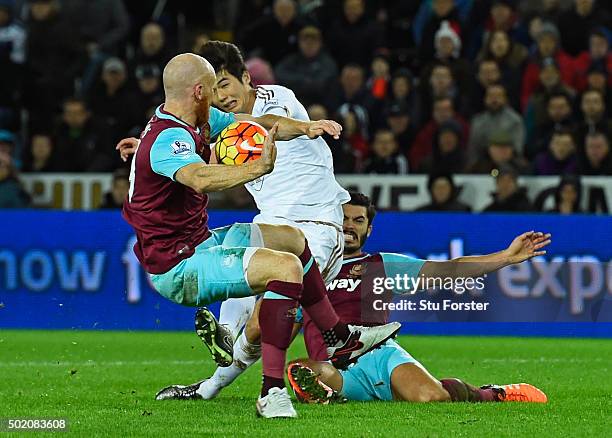 James Collins of West Ham appears to handle the shot from Ki Sung-Yeung of Swansea City during the Barclays Premier League match between Swansea City...