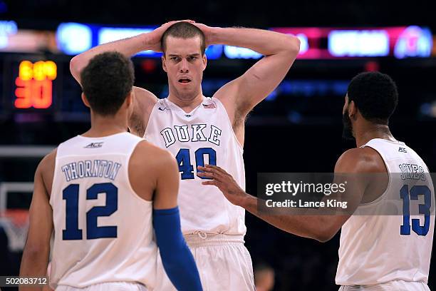 Marshall Plumlee reacts with teammates Derryck Thornton and Matt Jones of the Duke Blue Devils during their game against the Utah Utes during the...