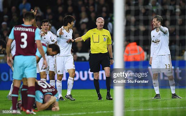 Swansea players appeal to referee Lee Mason after James Collins of West Ham appeared to handle the shot from Ki Sung-Yeung of Swansea City during the...