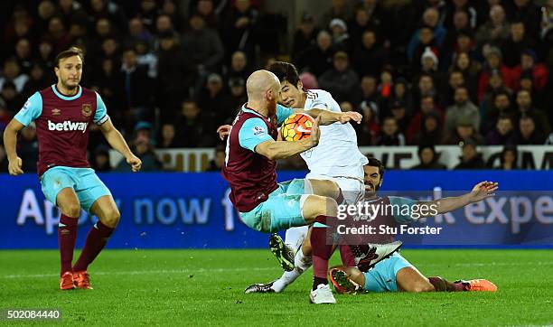 James Collins of West Ham appears to handle the shot from Ki Sung-Yeung of Swansea City during the Barclays Premier League match between Swansea City...