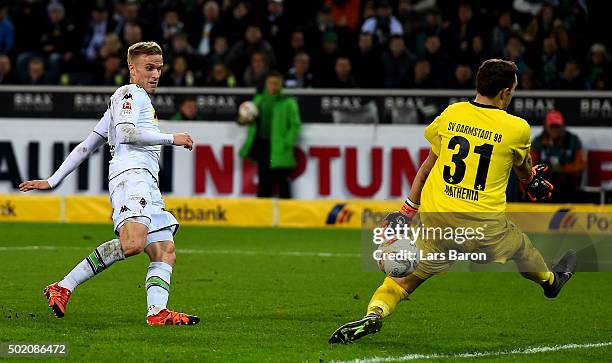 Oscar Wendt of Moenchengladbach scores his teams third goal against goalkeeper Christian Mathenia of Darmstadt during the Bundesliga match between...