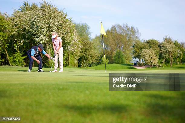 golf pro teaching the proper putting technique - golf lessons stock pictures, royalty-free photos & images