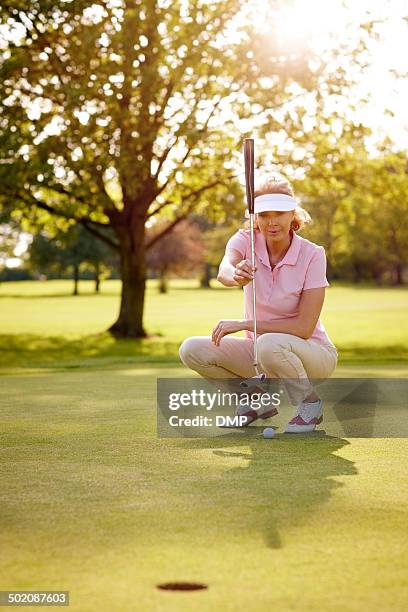 female golfer lining up for her shot - women's golf stockfoto's en -beelden