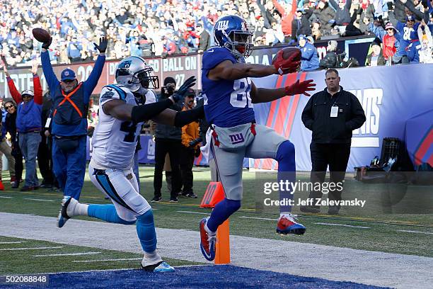 Rueben Randle of the New York Giants scores a 27 yard touchdown in the first quarter against Roman Harper of the Carolina Panthers during their game...