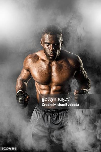 mma fighter on a smokey  background - combative sport stock pictures, royalty-free photos & images