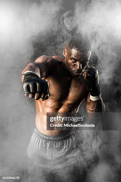 mma fighter on a smokey  background - boxing training stock pictures, royalty-free photos & images