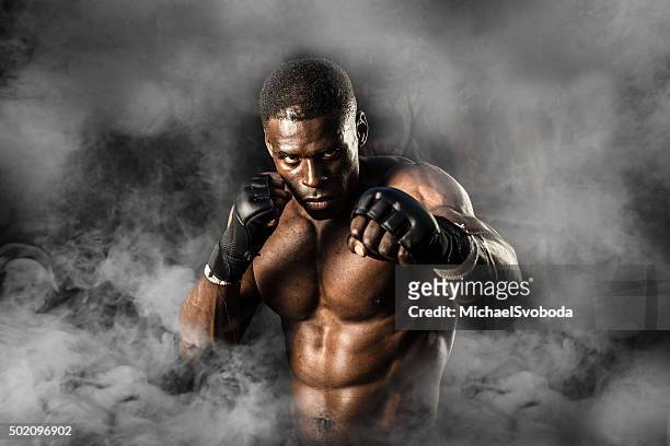 mma fighter on a smokey  background - combat sport stock pictures, royalty-free photos & images